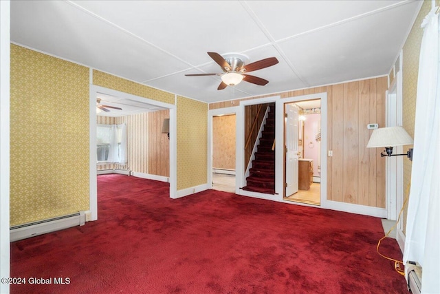 unfurnished room with carpet flooring, wooden walls, and a baseboard radiator