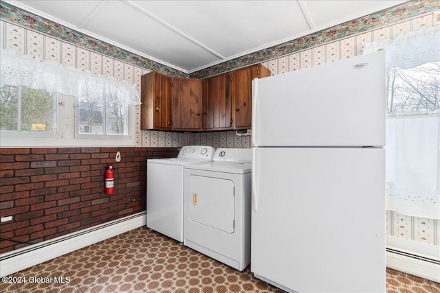 washroom with washing machine and dryer and a baseboard heating unit