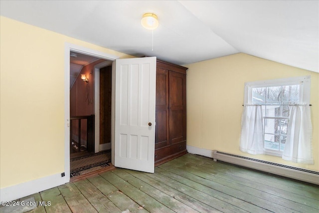 interior space featuring lofted ceiling, light hardwood / wood-style floors, and a baseboard radiator