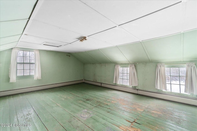 additional living space featuring wood-type flooring, vaulted ceiling, and plenty of natural light