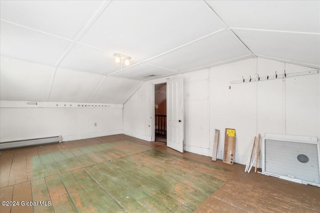 additional living space featuring lofted ceiling, dark hardwood / wood-style floors, and a baseboard heating unit