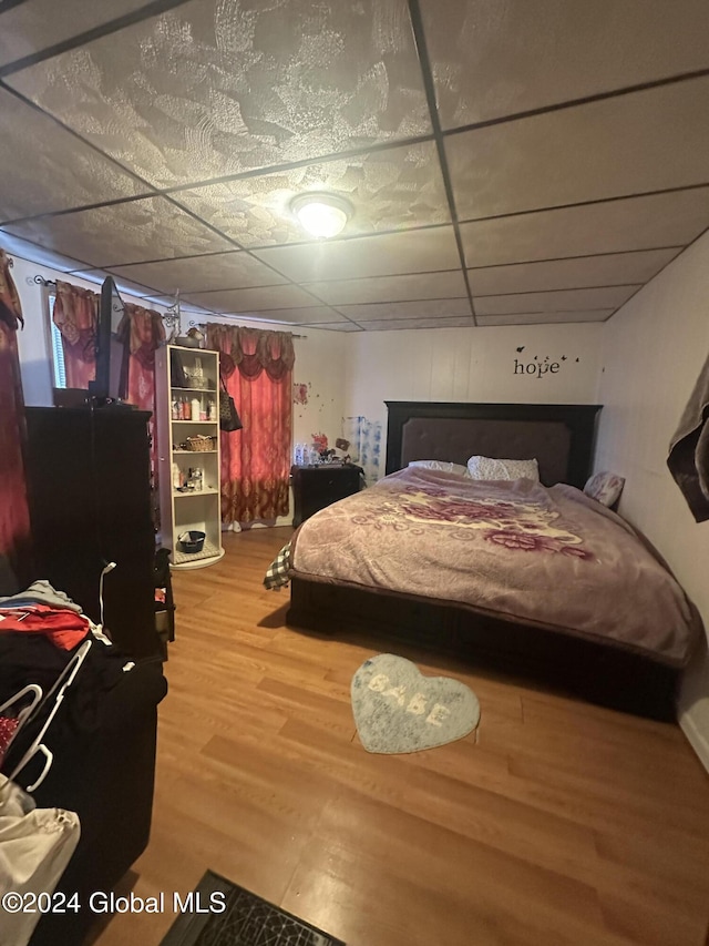 bedroom with hardwood / wood-style floors and a drop ceiling