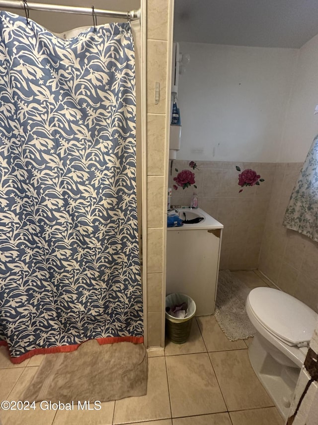 bathroom featuring tile patterned floors, a shower with curtain, sink, tile walls, and toilet