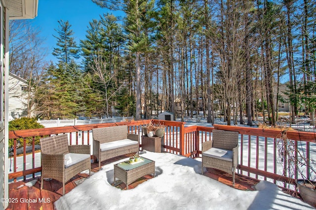 deck with an outbuilding, a shed, an outdoor hangout area, and a fenced backyard