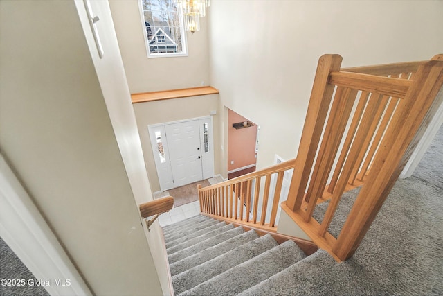 entrance foyer featuring tile patterned flooring, stairway, and a towering ceiling