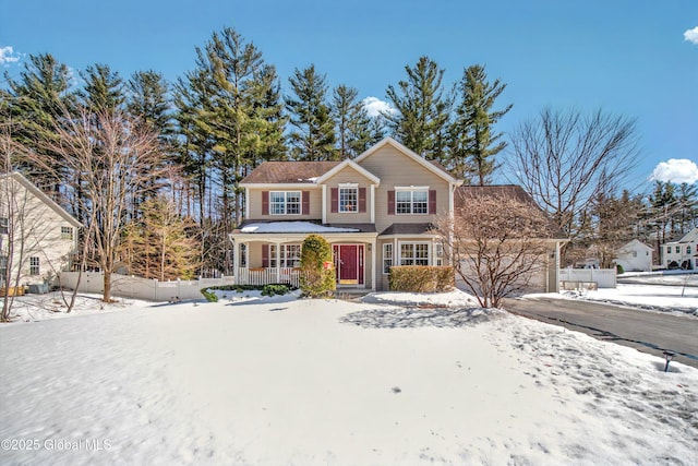 traditional home featuring a porch, driveway, an attached garage, and fence