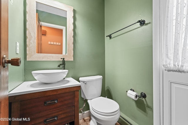 bathroom featuring vanity, toilet, and baseboard heating