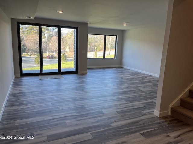 spare room featuring stairs, dark wood-style flooring, recessed lighting, and baseboards