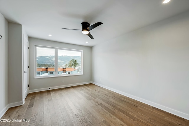 spare room featuring recessed lighting, ceiling fan, light wood-style flooring, and baseboards