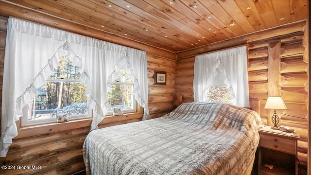 bedroom featuring wood ceiling and rustic walls