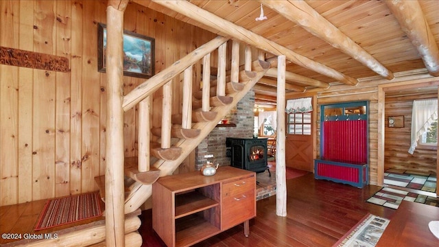 stairway with a wood stove, wooden ceiling, hardwood / wood-style flooring, beamed ceiling, and radiator heating unit