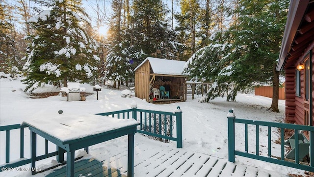 snow covered pool featuring a shed and a wooden deck