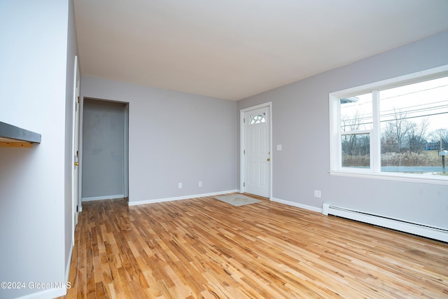 entrance foyer featuring a baseboard radiator and light hardwood / wood-style flooring