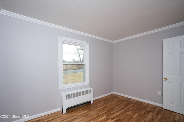 spare room with radiator, ornamental molding, and hardwood / wood-style flooring