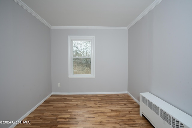 unfurnished room with radiator, crown molding, and light wood-type flooring