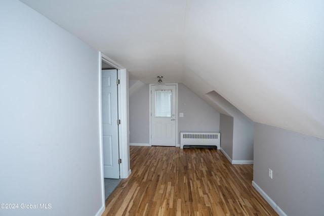 bonus room featuring radiator heating unit, lofted ceiling, and hardwood / wood-style floors