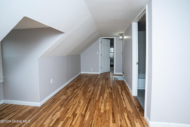 bonus room with wood-type flooring and vaulted ceiling