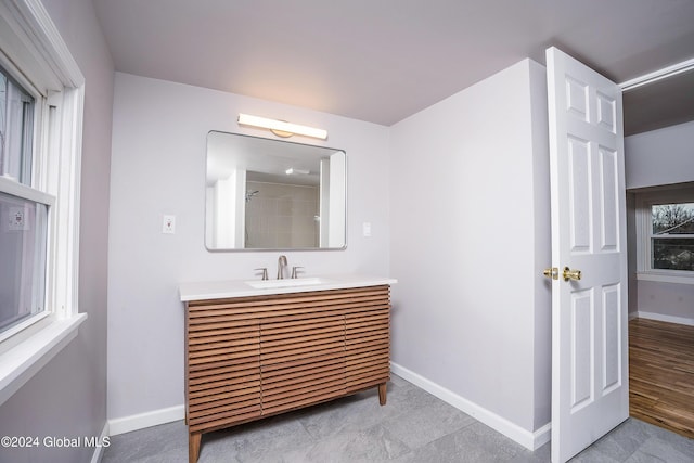 bathroom with a shower, wood-type flooring, and vanity