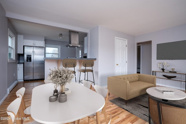 dining space with light wood-type flooring and a baseboard radiator