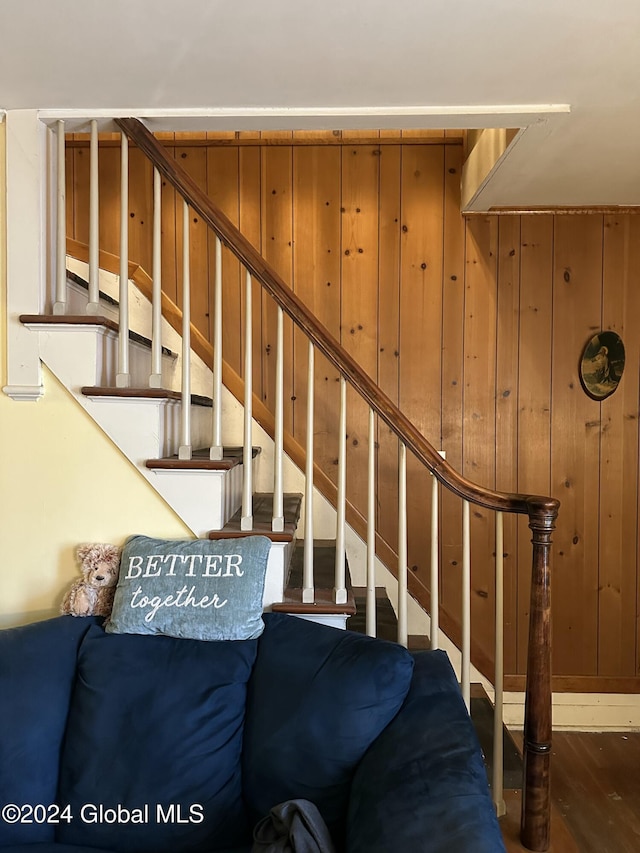 stairway with wood walls and hardwood / wood-style floors