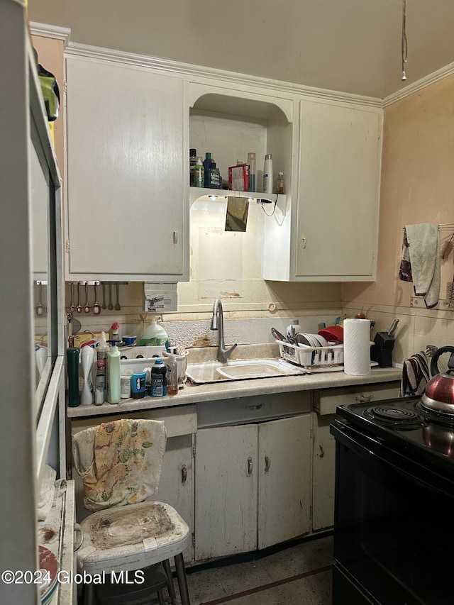 kitchen with white cabinetry, black electric range, and sink