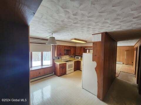 kitchen featuring baseboard heating and white appliances