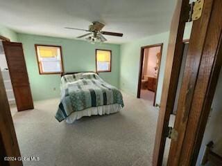 carpeted bedroom with multiple windows and ceiling fan