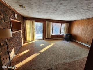 interior space with carpet flooring, wooden walls, and brick wall