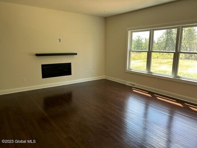 unfurnished living room with dark wood-type flooring