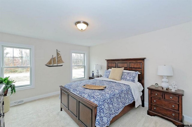 bedroom featuring light colored carpet and multiple windows