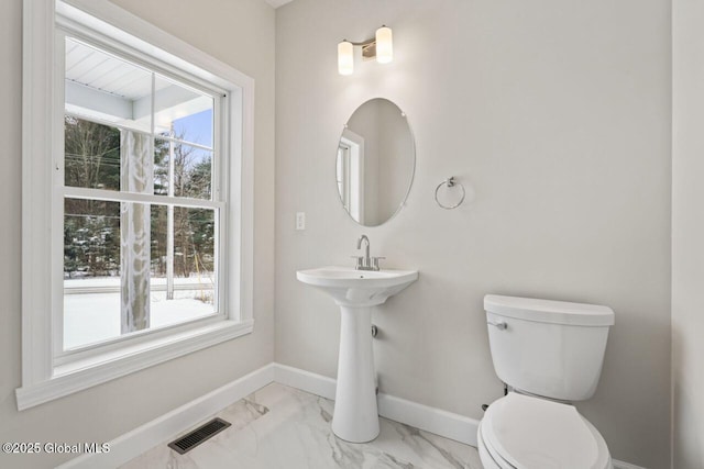 bathroom with a healthy amount of sunlight and toilet