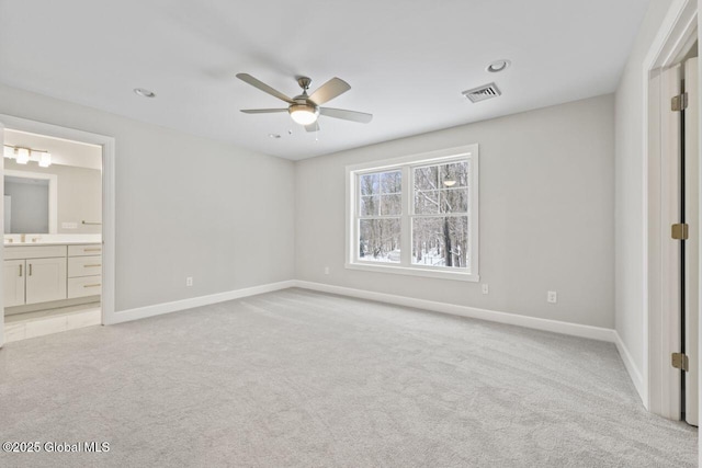 unfurnished bedroom featuring ensuite bathroom, light carpet, and ceiling fan