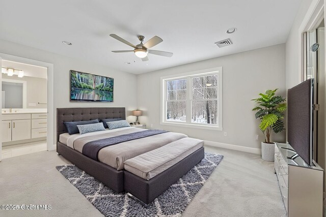 carpeted bedroom with ceiling fan and ensuite bath