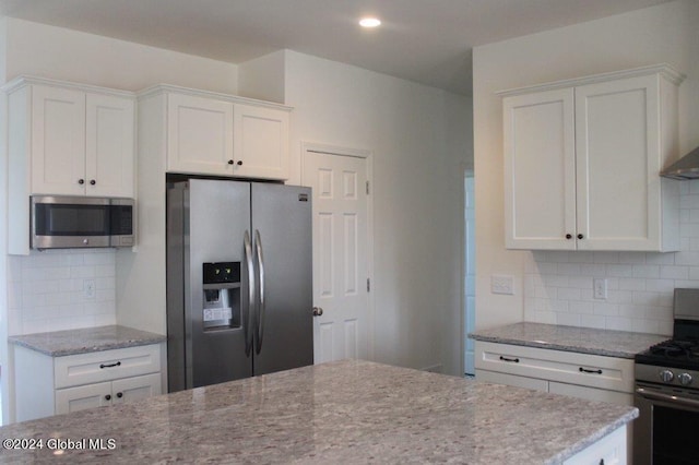 kitchen featuring tasteful backsplash, white cabinets, and appliances with stainless steel finishes