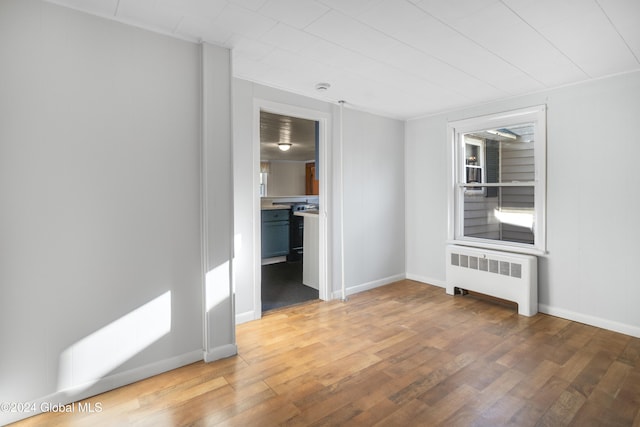 unfurnished room featuring radiator and wood-type flooring