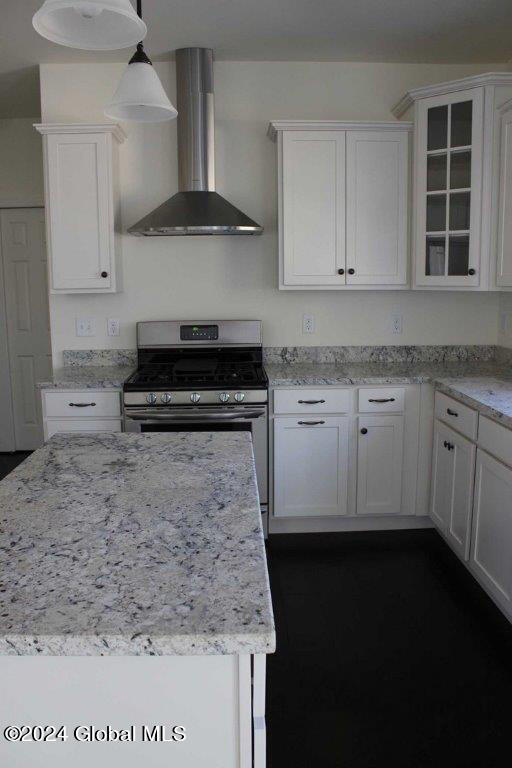 kitchen with white cabinets, stainless steel range oven, and wall chimney range hood