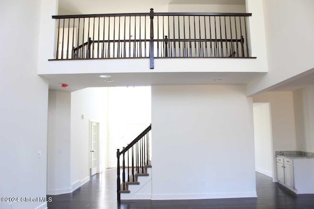 staircase with hardwood / wood-style floors and a high ceiling