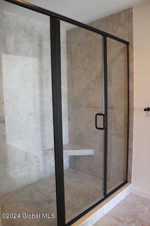 bathroom with tile patterned floors and a shower with shower door