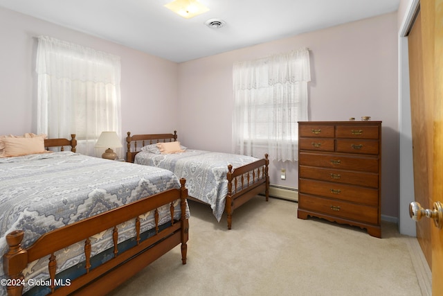 carpeted bedroom featuring a closet and a baseboard heating unit