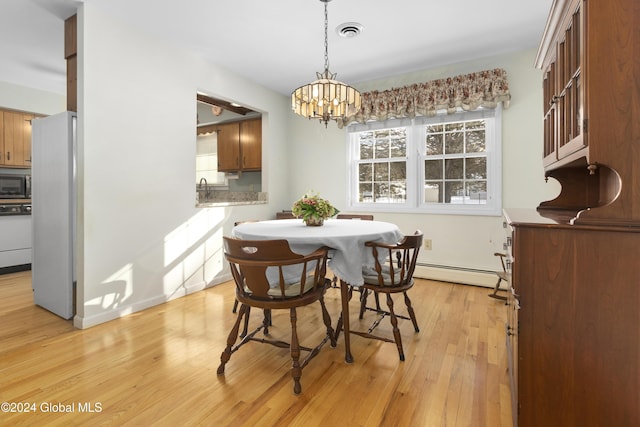 dining area with light hardwood / wood-style floors, a baseboard radiator, and a notable chandelier