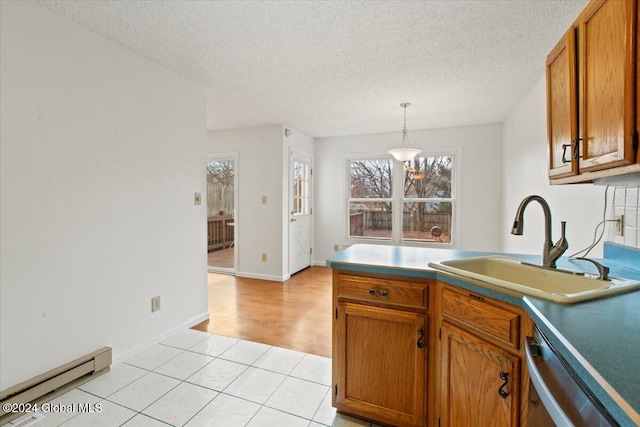 kitchen featuring baseboard heating, sink, decorative light fixtures, dishwasher, and light hardwood / wood-style floors