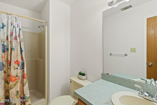 bathroom featuring vanity, toilet, a textured ceiling, and walk in shower