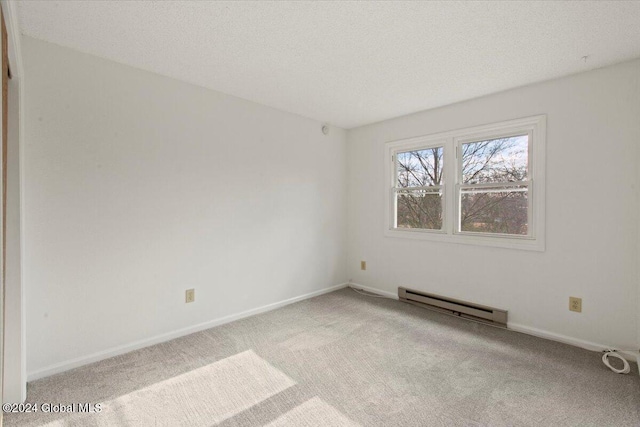 carpeted empty room with a textured ceiling and a baseboard radiator