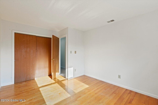 unfurnished bedroom featuring hardwood / wood-style floors and a closet