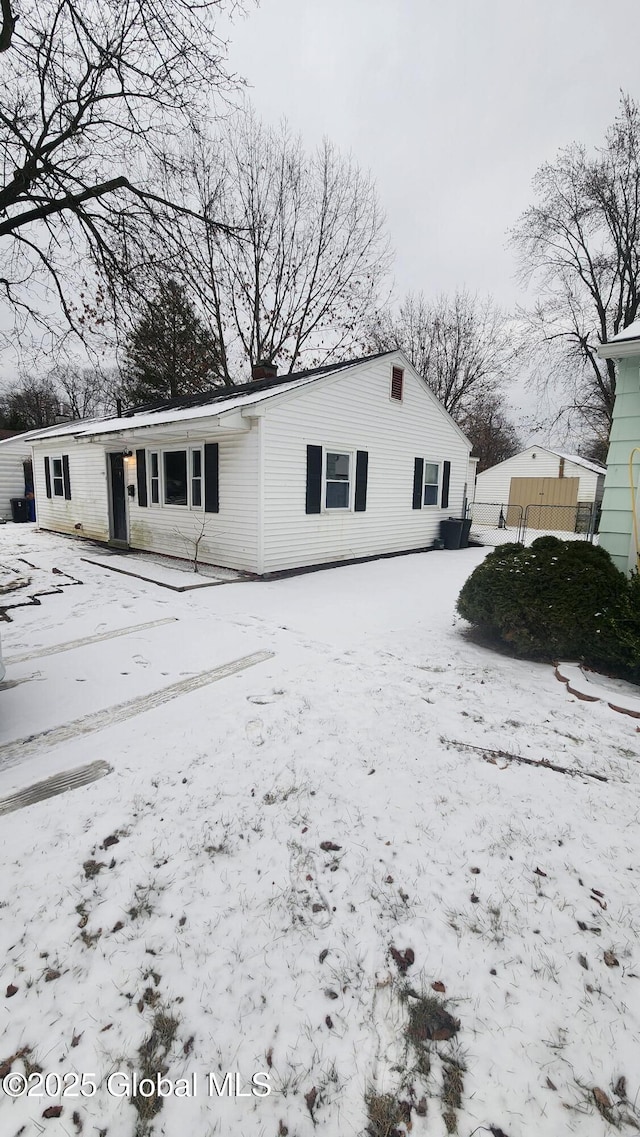 view of snow covered back of property