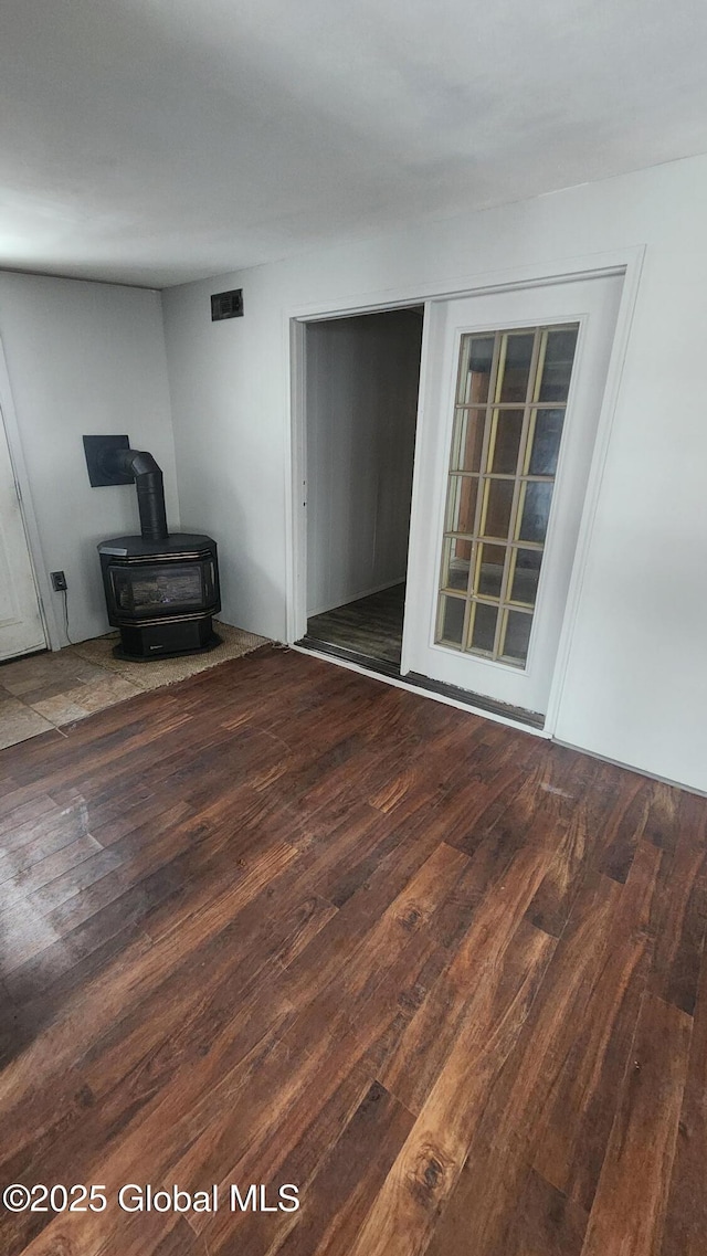 living room with dark hardwood / wood-style flooring and a wood stove