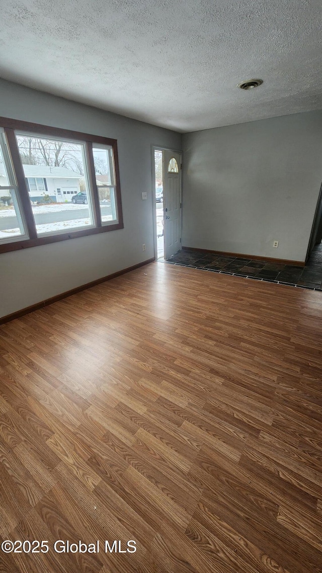 foyer entrance featuring dark wood-type flooring and a textured ceiling