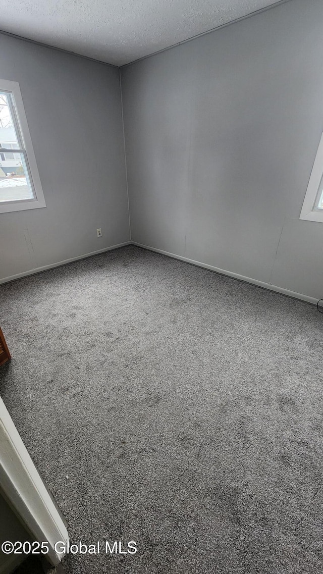 carpeted empty room featuring a textured ceiling