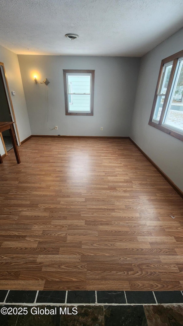 spare room with hardwood / wood-style flooring and a textured ceiling