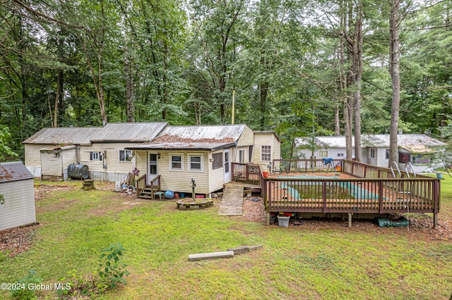 back of property with a lawn and a wooden deck